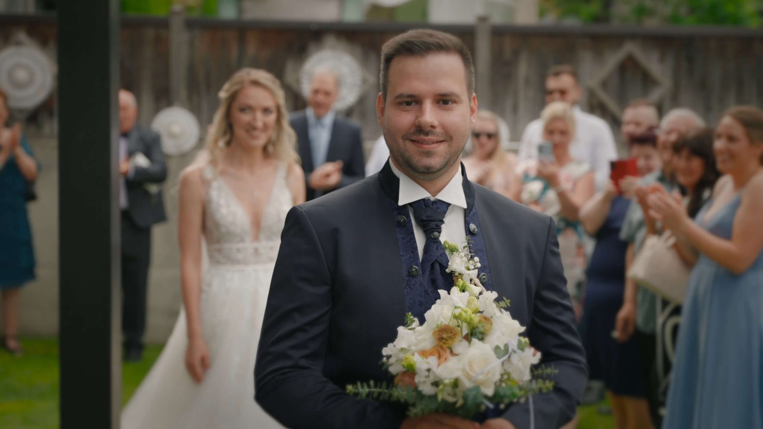 Bräutigam hält Brautstrauß beim First Look einer orthodoxen Hochzeit in Schwaz