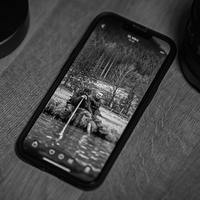 Smartphone mit Schwarz-Weiß-Foto von zwei Männern in Tiroler Landschaft – Symbolbild für Social Media Betreuung in Tirol