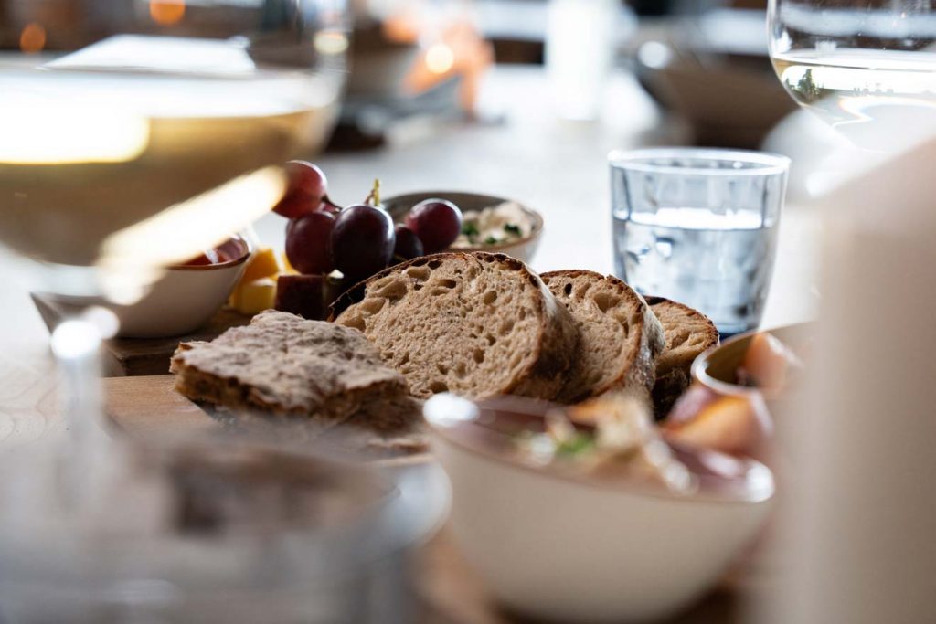 Frisches Bauernbrot, Trauben und Käse auf einer Jausenplatte in der Umbrüggler Alm Innsbruck – regionale Spezialitäten in Tirol.