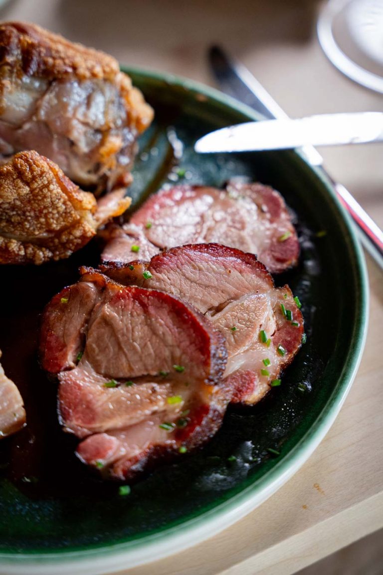 Traditionelle Tiroler Schlachtplatte mit knusprigem Schweinsbraten und Fleischspezialitäten auf der Umbrüggler Alm in Innsbruck.