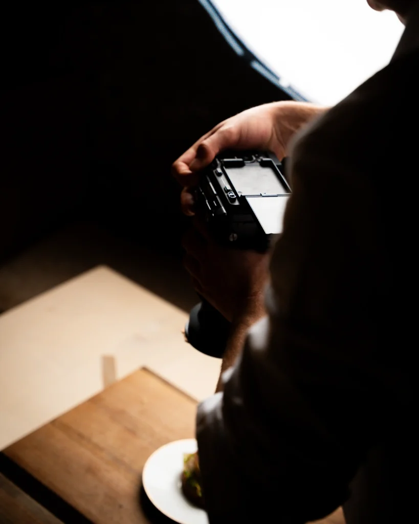 Videograf fotografiert angerichtetes Gericht bei Food Shooting mit Softbox Beleuchtung.