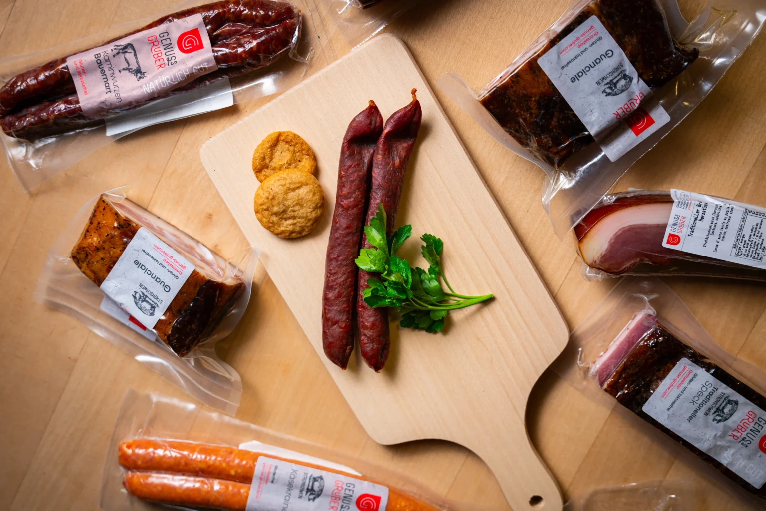 Genuss Gruber Wurst- und Specksortiment auf Holzbrett mit Kaminwurzen und regionalen Fleischprodukten aus Südtirol