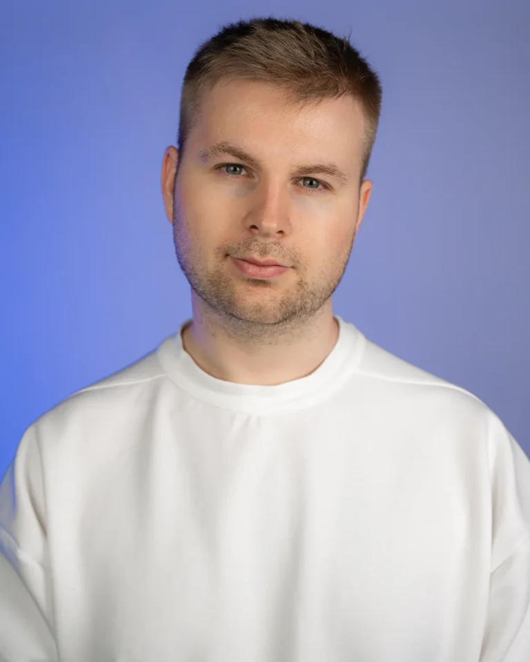 Porträt von Julian Haberl von JH-Creative im Fotostudio mit blauem Hintergrund