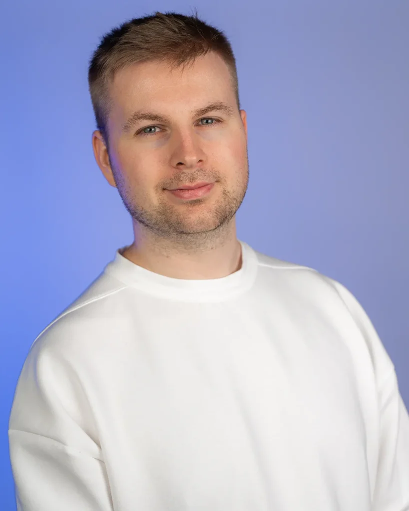 Porträt von Julian Haberl von JH-Creative vor blauem Studiohintergrund