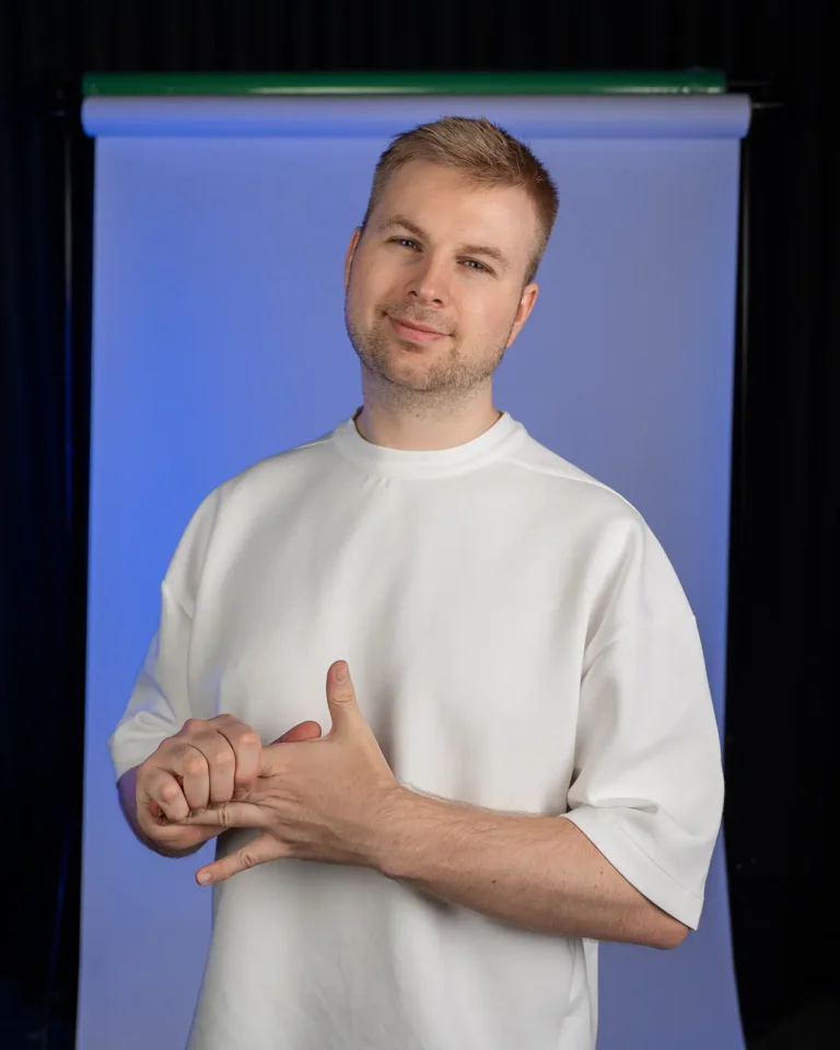 Porträt eines Foto und Videoproduzenten (Julian Haberl) im Studio vor blau beleuchtetem Hintergrund.